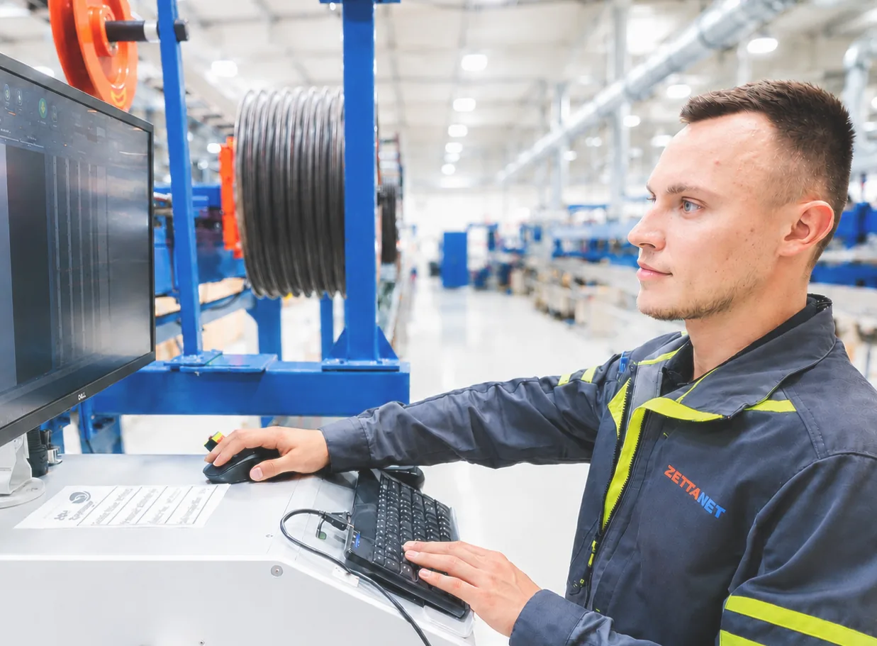 Zettanet technician monitoring optical cable production at the Kisbér factory